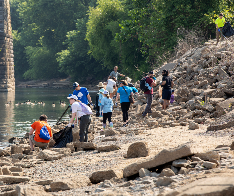 WAVE Water Warriors cleaning up in the ohio river. There are 10 people carrying trash bags and grabbers to load the trash into bags.